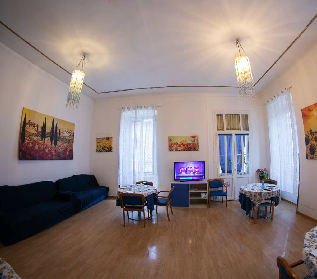 Salotto luminoso con lampadari di cristallo e arredi accoglienti – Residenza Anni Sereni